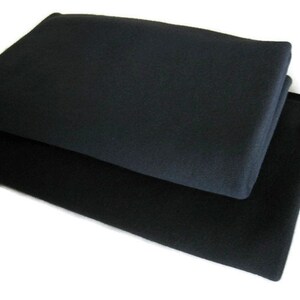 May include: Two black fabric squares stacked on top of each other. The top square is slightly larger than the bottom square.