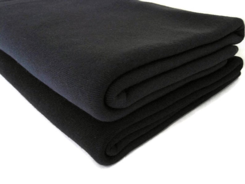 May include: A black fleece blanket folded in thirds. The blanket is soft and plush, and it is perfect for keeping warm on a cold day.