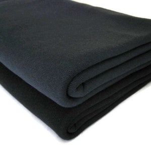 May include: Two folded pieces of black fabric. The fabric is soft and has a smooth texture.