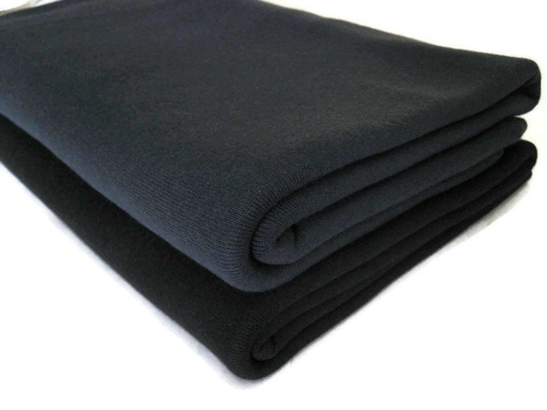 May include: Two folded pieces of black fabric. The fabric is soft and has a smooth texture.