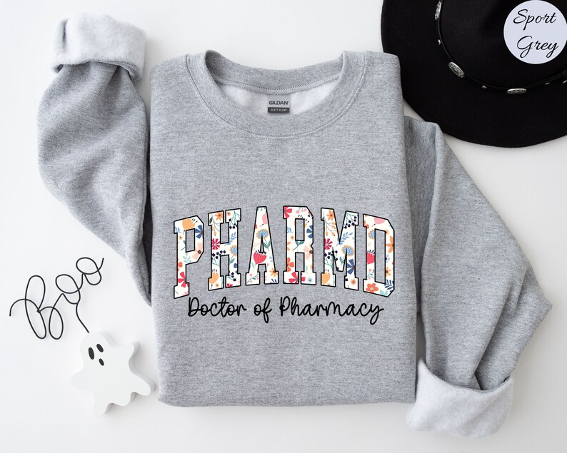 May include: A gray sweatshirt with a floral print design that says "PHARMD Doctor of Pharmacy".