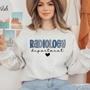 May include: A gray sweatshirt with the text "RADIOLOGY department" in blue and black lettering with a small black heart below the text.