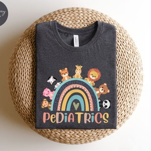 May include: Dark grey heather t-shirt with a rainbow and animals on it. The text "PEDIATRICS" is below the rainbow.