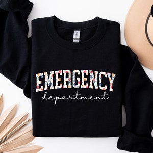 May include: Black sweatshirt with a floral print of the words "EMERGENCY department" in white.