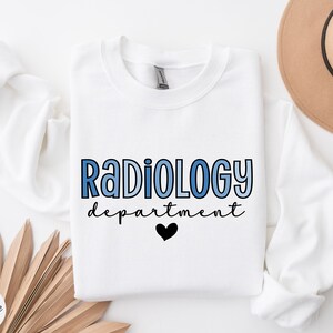 May include: White sweatshirt with the text "Radiology department" in blue and black lettering with a black heart.