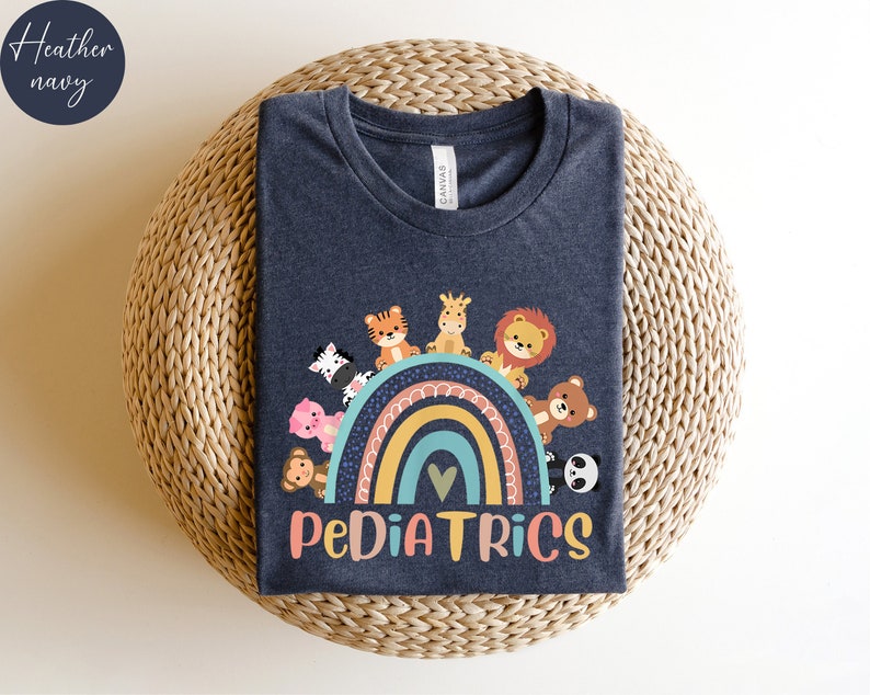 May include: A dark heather navy blue t-shirt with a rainbow and cute animal graphic. The text "PEDIATRICS" is printed below the rainbow.