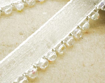 Ribete blanco iridiscente con cuentas y borde de cuentas.