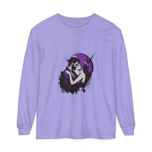 Könnte beinhalten: Ein Langarmshirt mit einem lila und weißen Grafikdruck eines sich umarmenden Paares. Die Grafik ist vor einem dunkelvioletten Hintergrund mit einem weißen Mond und Sternen platziert.
