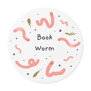 Könnte beinhalten: Ein weißer Kreis mit pinken Würmern mit lächelnden Gesichtern und dem Text "Book Worm" in Schwarz.