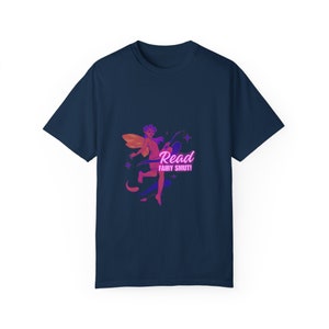 Puede incluir: Camiseta azul marino con una ilustración colorida de un hada con alas naranjas y rosas y el texto "Read Fairy Smut!". El hada sostiene una varita mágica. El texto está en un degradado rosa y morado.