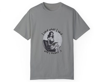 May include: A grey t-shirt with a black and white illustration of a woman sitting in a chair. The text "I said what I said and I meant it" is printed on the shirt.