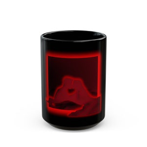 Könnte beinhalten: Schwarze Keramiktasse mit einer roten Silhouette eines sich umarmenden Paares in einem roten Rahmen.