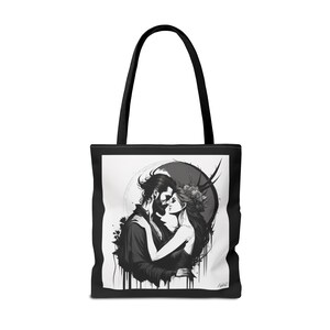 Könnte beinhalten: Schwarze und weiße Einkaufstasche mit einem Paar, das sich in einer romantischen Pose umarmt. Das Paar ist von einem kreisförmigen Design mit Mond und Sternen umgeben. Die Tasche hat schwarze Henkel.