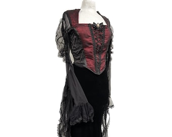 May include: A black and red gothic-style dress with a lace bodice and a long, flowing skirt. The dress has a fitted bodice with a lace-up front and a full skirt with layers of ruffles.