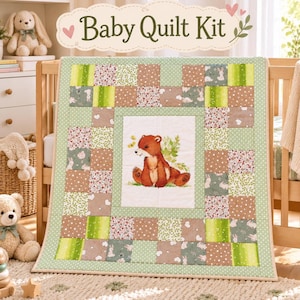 Puede incluir: Un kit de edredón para bebé con un panel central que muestra una ilustración de un oso pardo, rodeado por un borde de retazos de cuadrados de tela verdes, marrones y blancos con patrones florales, de conejos y de lunares, etiquetado Baby Quilt Kit.