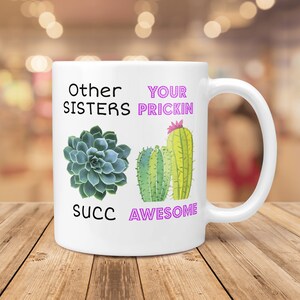 May include: White ceramic mug with a cactus and succulent design. The mug reads "Other Sisters Succ" and "Your Prickin Awesome".