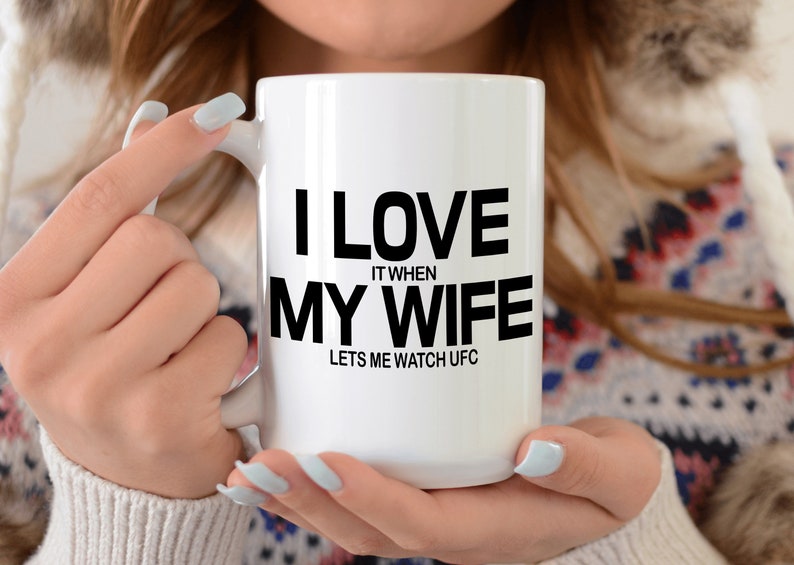 Pode incluir: Caneca de caf&eacute; de cer&acirc;mica branca com texto preto que diz "Eu amo quando minha esposa me deixa assistir UFC".