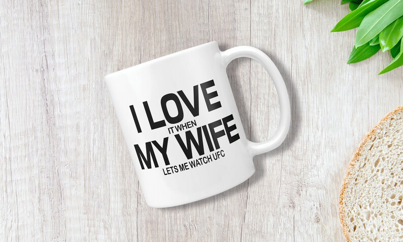 Pode incluir: Caneca de caf&eacute; de cer&acirc;mica branca com texto preto que diz "Eu amo quando minha esposa me deixa assistir UFC".