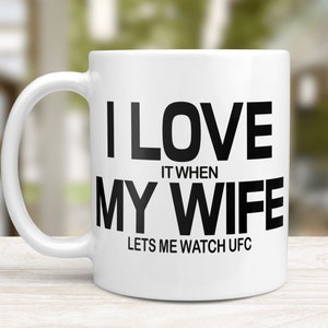 Pode incluir: Caneca de caf&eacute; de cer&acirc;mica branca com texto preto que diz "Eu amo quando minha esposa me deixa assistir UFC".