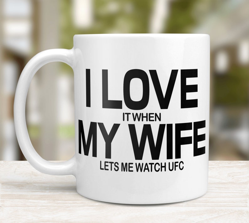 Pode incluir: Caneca de caf&eacute; de cer&acirc;mica branca com texto preto que diz "Eu amo quando minha esposa me deixa assistir UFC".