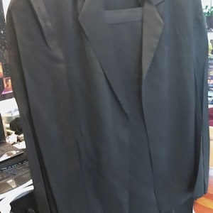 May include: A black blazer with a long, flowing design. The blazer has a classic lapel collar and a single button closure.