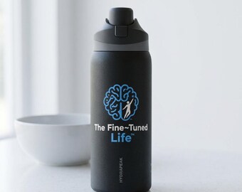 May include: A matte black water bottle with a dark gray lid and a push-button spout. The front features a blue graphic of a brain silhouette with a person reaching upward, accompanied by the white and blue text The Fine-Tuned Life and Hydrapeak.