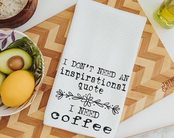 Puede incluir: Toalla de cocina blanca con texto negro que dice "No necesito una cita inspiradora, necesito café". La toalla está sobre una tabla de cortar de madera con un patrón de chevron.