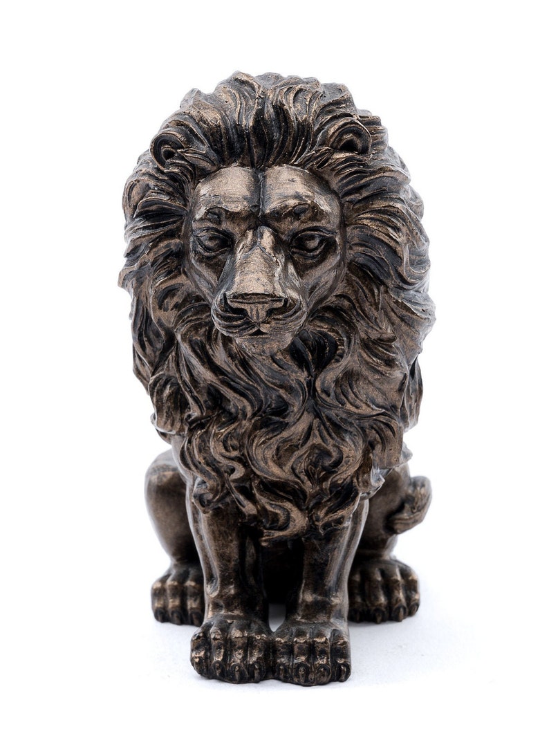 May include: A bronze lion statue with a detailed mane and a seated pose. The lion has a serious expression and is looking straight ahead.