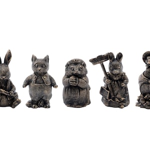 May include: Five small, bronze-colored figurines of animals. The figurines are of a rabbit holding a carrot, a cat wearing a vest, a hedgehog, a rabbit holding a broom, and a duck wearing a hat.