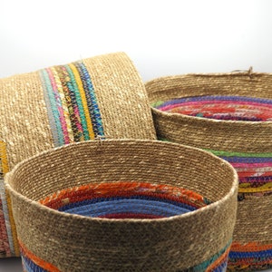 Peut inclure: Trois paniers tissés avec des bordures en tissu coloré. Les paniers sont faits de matériaux naturels et ont un aspect rustique et artisanal.