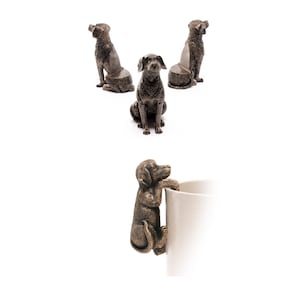 May include: Three bronze dog figurines, one sitting and two standing, with a fourth bronze dog figurine hanging from a white mug.