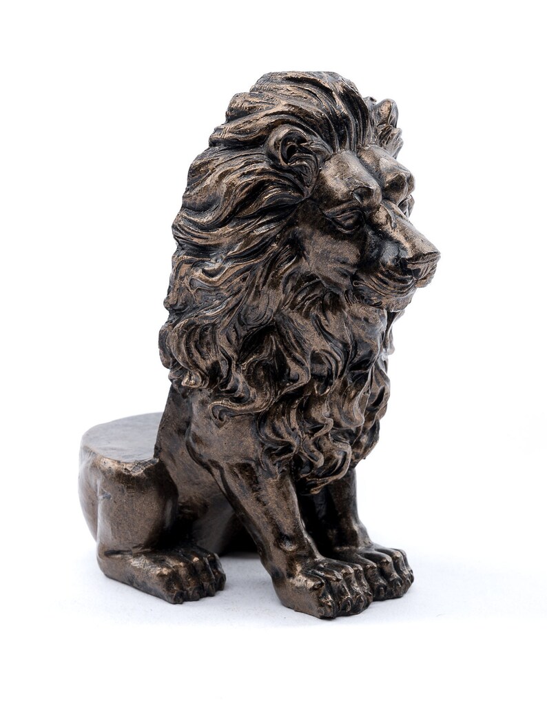 May include: A bronze lion statue with a detailed mane and a seated pose. The lion has a realistic appearance with a textured surface.