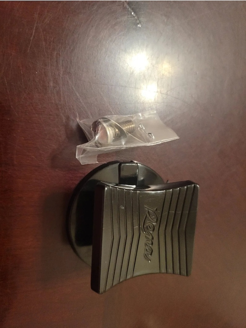 May include: Black plastic lid with a black lever and the word "Rema" embossed on it. A small plastic bag containing a screw is also visible.