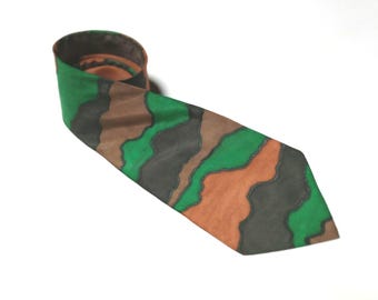 May include: A green, brown, and black patterned tie. The tie has a wavy, abstract design.