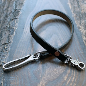 Cordón de cuero para billetera en Horween Chromexcel negro, con herrajes de alpaca en forma de anzuelo. Correa para billetera con bolsillo trasero y llavero largo. Fabricado en el Reino Unido.