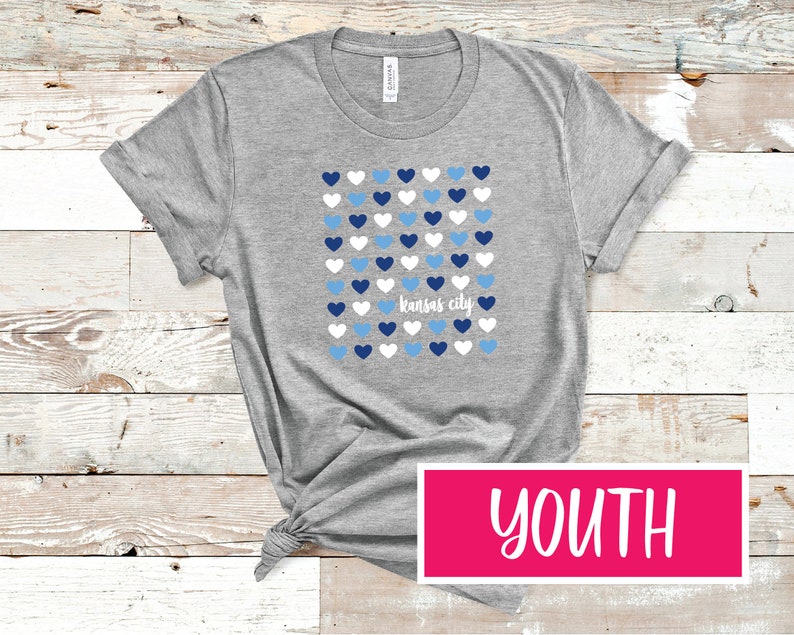 May include: Gray youth t-shirt with a pattern of blue and white hearts and the text "Kansas City".