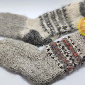 May include: Two pairs of gray wool socks with different patterns. One pair has a gray and white striped pattern, the other has a gray, white, and orange pattern.