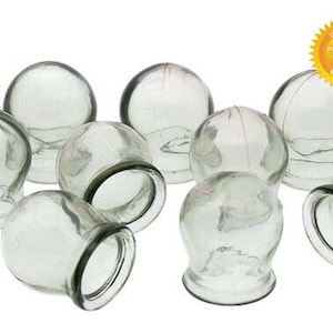 Pode incluir: Um conjunto de dez copos de terapia de ventosa de vidro transparente. Os copos são redondos e têm uma superfície lisa e polida.