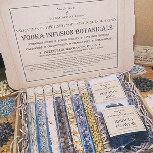 May include: A set of glass tubes filled with various dried botanicals, including coriander seeds, spiced berries, lavender flowers, cacao nibs, coconut chips, orange peel, and lemongrass. The tubes are arranged in a wooden box with a label that reads "Vodka Infusion Botanicals".