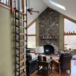 Loft ladder sitting in an elegant residential home. This ladder is customized with stained wood treads to match the customers home