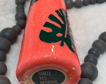 Vaso de purpurina de coral con hojas de monstera