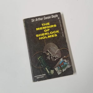 May include: A vintage copy of "The Memoirs of Sherlock Holmes" by Sir Arthur Conan Doyle. The book cover is dark with yellow lettering and an illustration of a pipe, hat, and other detective-themed items. The words "Authorized Edition" are printed at the bottom.