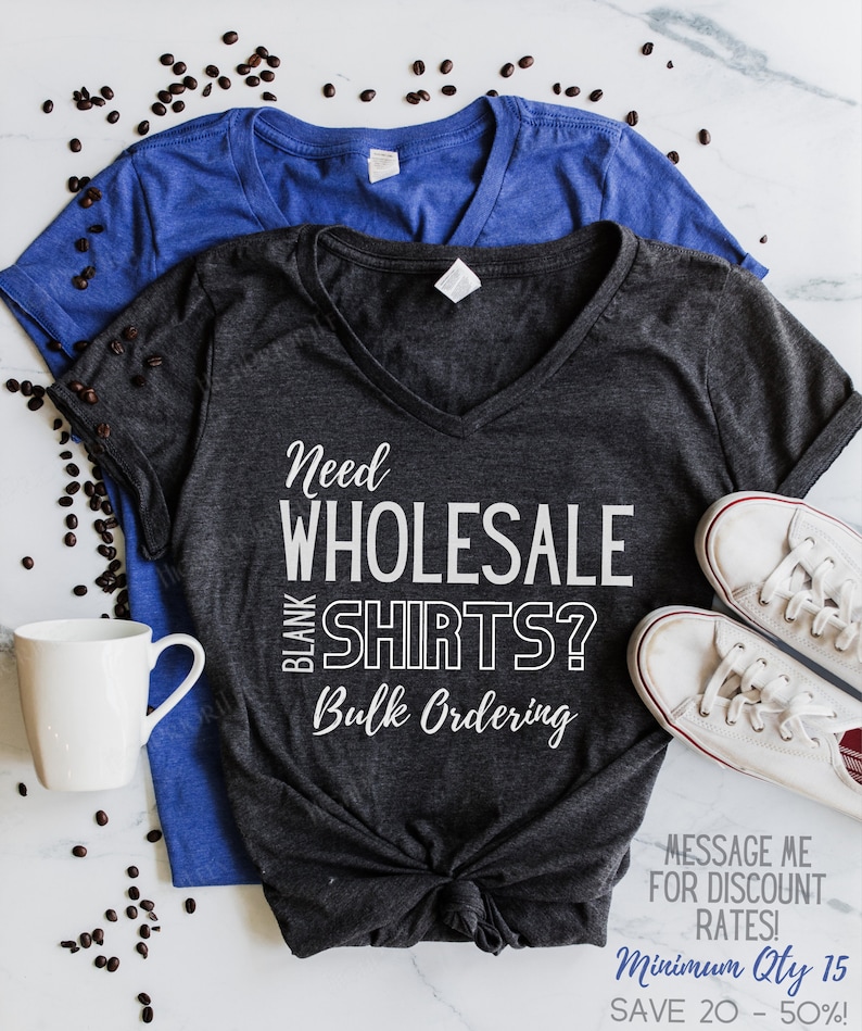 May include: A dark gray V-neck t-shirt with the text "Need Wholesale Blank Shirts? Bulk Ordering" in white. The text "Message me for discount rates! Minimum Qty 15 Save 20 - 50%!". is also printed on the shirt.