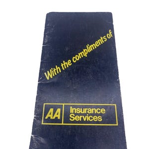 May include: A black booklet with the text "With the compliments of AA Insurance Services" in yellow lettering.