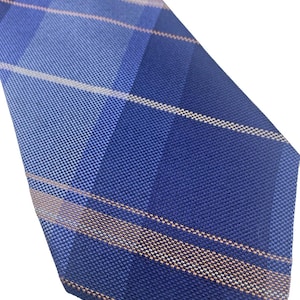 May include: A blue tie with a plaid pattern. The tie features shades of blue and tan stripes. The fabric has a textured appearance. The tie is angled diagonally across the frame.