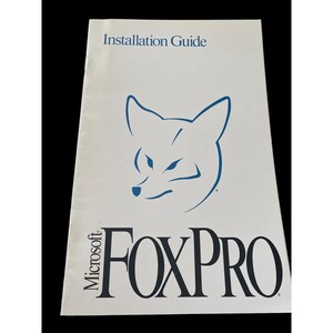 May include: A white Microsoft FoxPro installation guide manual featuring a blue fox head graphic at the top center and the black text Microsoft FOXPRO printed prominently at the bottom of the front cover with a clean, professional layout.