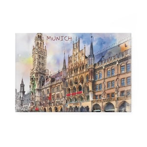 May include: Watercolor painting of Munich, Germany, featuring the Neues Rathaus (New Town Hall). The artwork showcases the building's intricate architecture, with spires and arched windows. The word "MUNICH" is written across the top.
