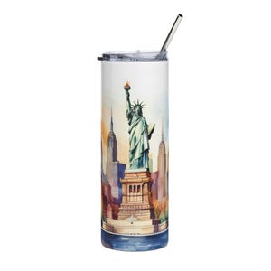 Könnte beinhalten: Ein Edelstahlbecher mit einer Aquarellillustration der Freiheitsstatue und der Skyline von New York City. Der Becher hat einen silbernen Strohhalm und einen weißen Deckel. Das Design zeigt Farbtöne von Blau, Orange und Braun.