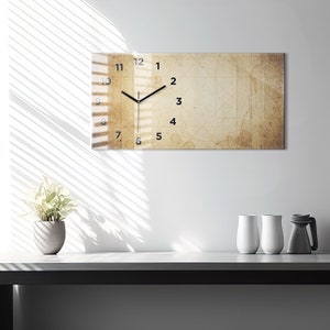 May include: A rectangular clock with black hands and Roman numeral markings on a beige background with a grid pattern. The clock is hanging on a white wall.