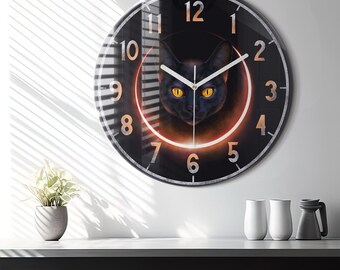 May include: A black cat with yellow eyes is featured on a round clock face with black numbers and a white clock hand. The cat is surrounded by a glowing orange ring.
